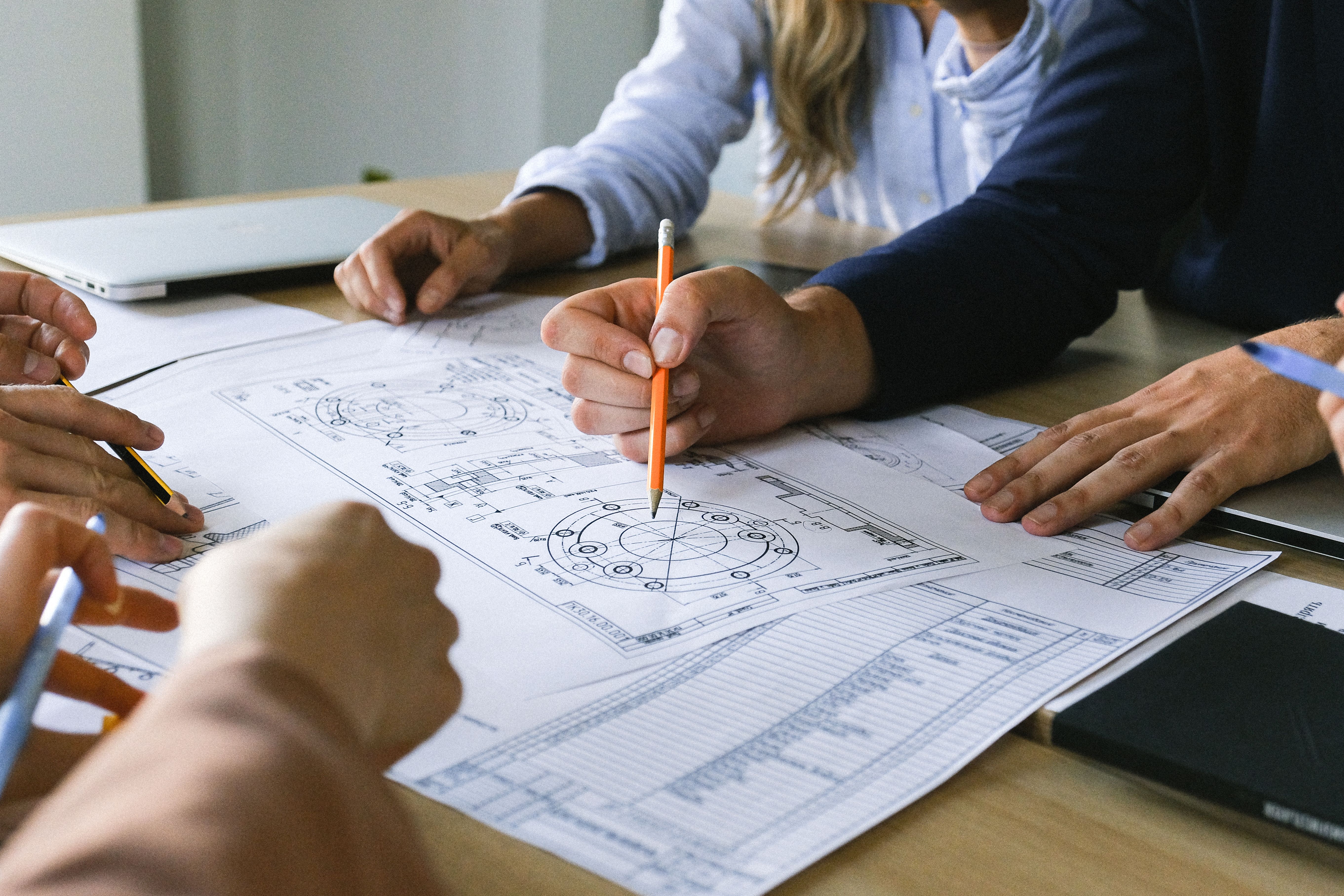 Engineering team reviewing drawings together at an office table