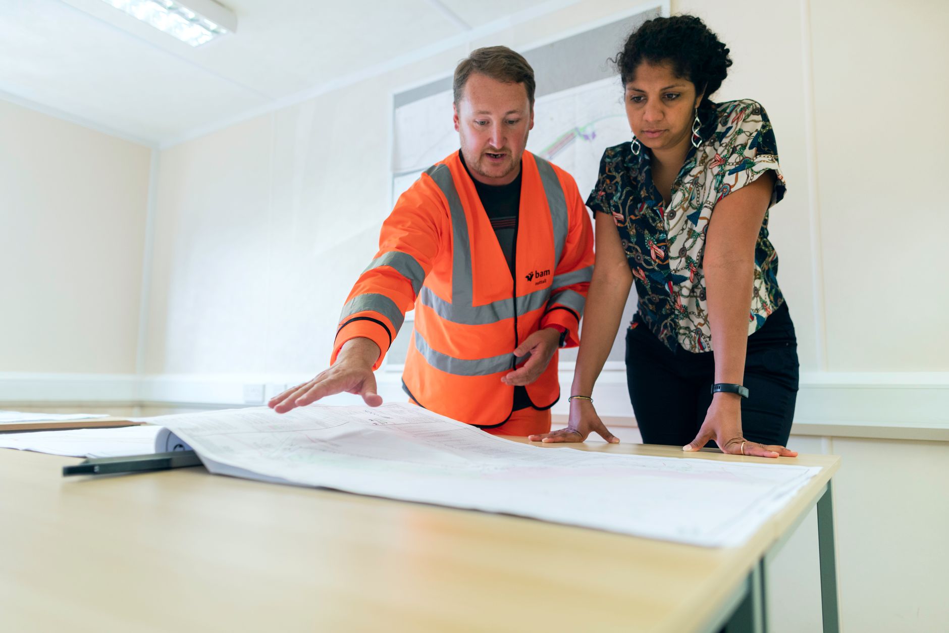 Two engineers reviewing project drawings in an office